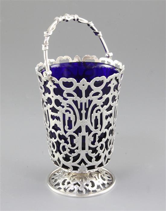 An early Victorian silver swing handled sugar basket and blue glass liner, Height: to handle 7 ¾”/195mm Top Dia 4”/100mm